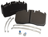 Set of brake pads with metal shims and a bottle on a white background