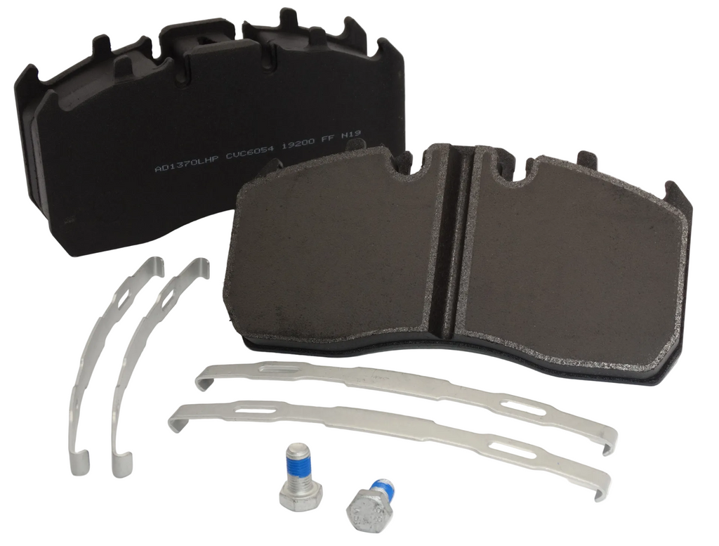 Set of brake pads with metal shims and a bottle on a white background